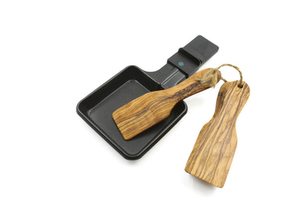 Close-up of the handcrafted olive wood raclette spatulas