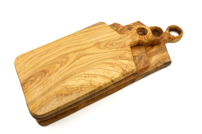 A cutting board made of olive wood, with a practical ringed handle in a rectangular shape