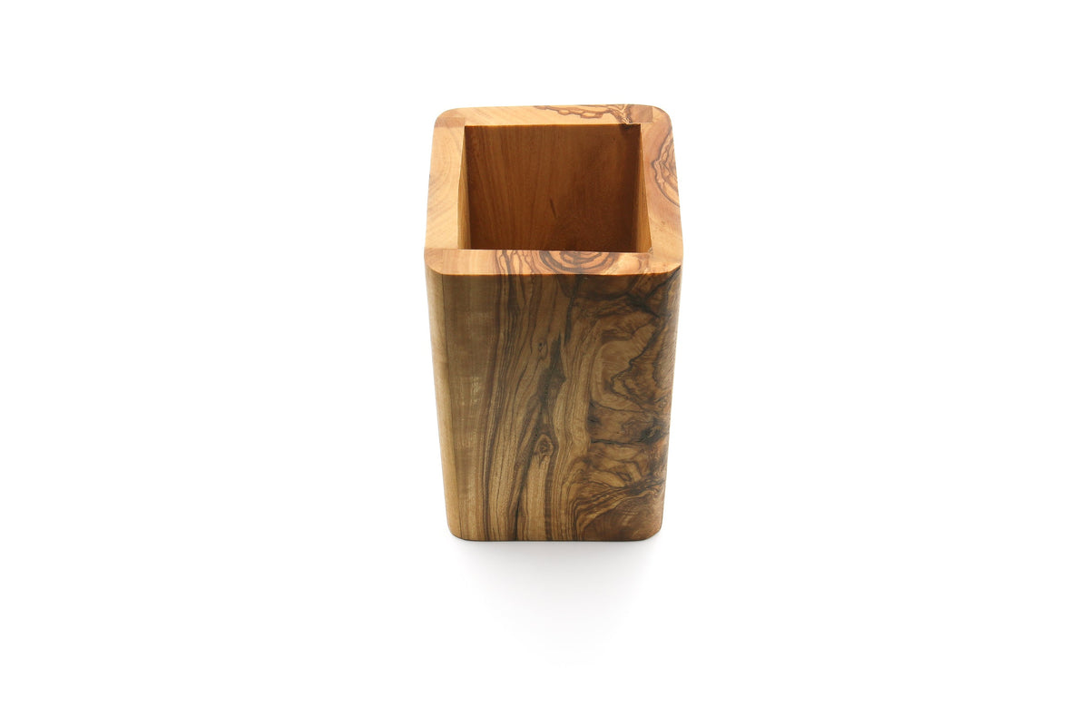Olive wood utensil holder with spatulas, on a kitchen counter