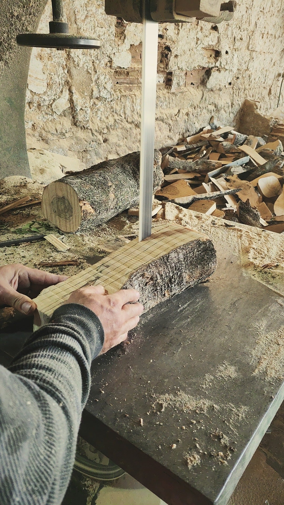 Old olive tree trunk being sawn into blocks for handmade olive wood boards